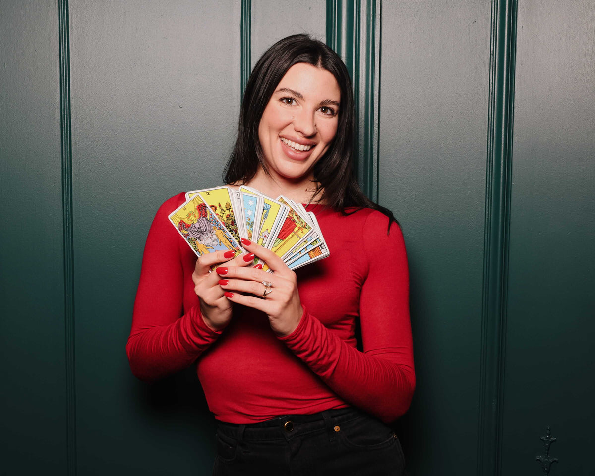Tarot by Alexis holding tarot cards at Intimissimi's Valentine's collection launch at The Plaza Hotel in New York City.